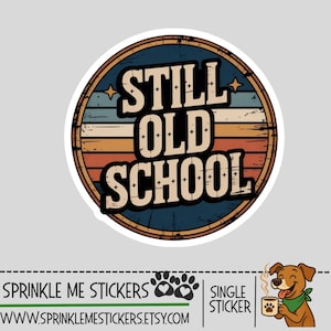 May include: A circular sticker featuring the text STILL OLD SCHOOL in bold black letters. The background consists of horizontal stripes in shades of blue, beige, and orange, enclosed within a dark circular border with small star accents.