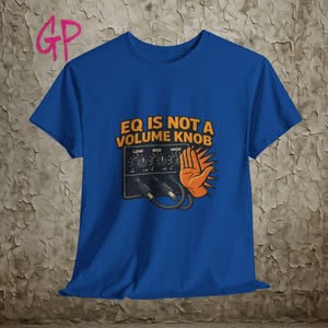 May include: Royal blue t-shirt with the text "EQ IS NOT A VOLUME KNOB" above a graphic of an audio equalizer and an orange hand. The shirt has a crew neck and short sleeves.