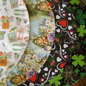 Peut inclure: Quatre cercles en tissu avec des motifs différents. Le premier cercle a un fond blanc avec un thème de jardinage, avec un arrosoir, des fleurs et des outils de jardinage. Le deuxième cercle a un fond bleu clair avec un motif floral et un lapin. Le troisième cercle a un fond noir avec un motif de cœur blanc. Le quatrième cercle a un fond noir avec un motif de trèfle vert.
