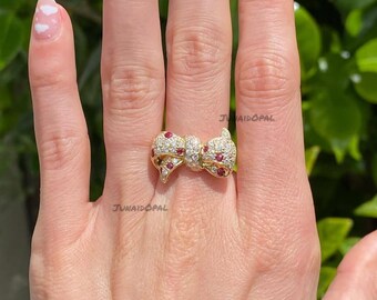 Anillo de plata de ley con baño de oro y lazo, joya llamativa con circonitas cúbicas y rubíes.
