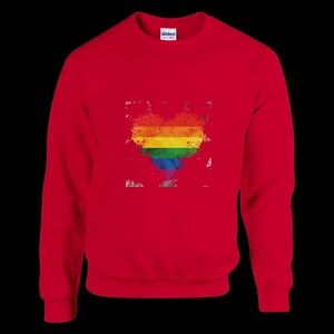 Könnte beinhalten: Ein rotes Sweatshirt mit einem verwitterten Regenbogenherz-Design. Das Herz besteht aus horizontalen Streifen in den Farben der LGBTQ+-Pride-Flagge. Das Sweatshirt hat einen Rundhalsausschnitt und lange Ärmel.
