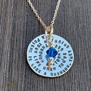 May include: Silver necklace with a round pendant that reads "They've you've a storm. When you're through a friend is like a rainbow. Be bright."  The pendant has a small blue crystal charm.