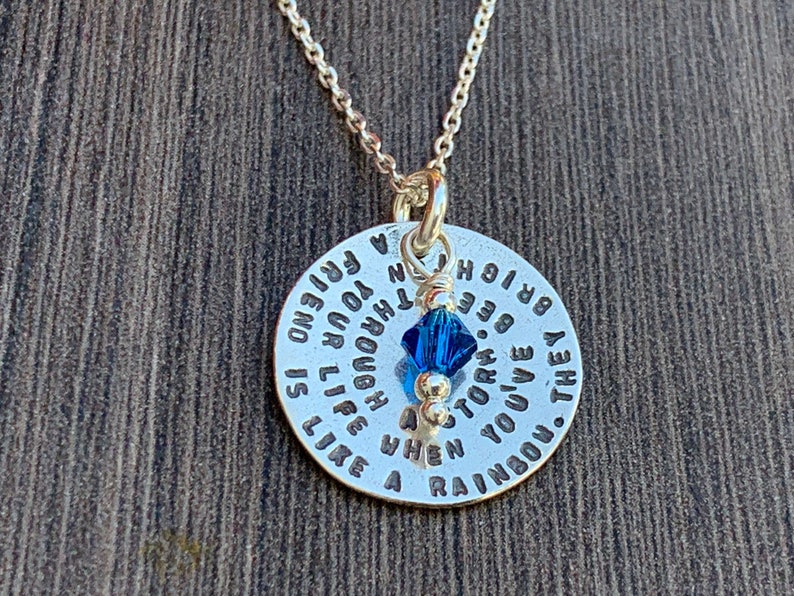 May include: Silver necklace with a round pendant that reads "They've you've a storm. When you're through a friend is like a rainbow. Be bright."  The pendant has a small blue crystal charm.