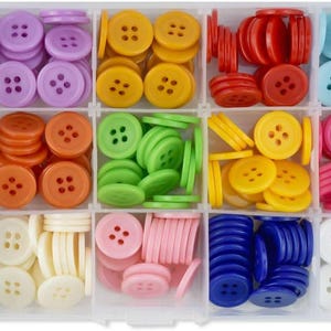 May include: A clear plastic organiser filled with a variety of colourful buttons. The buttons are round with four holes and come in shades of brown, purple, yellow, red, blue, pink, green, white, and orange. Suitable for sewing and crafts.
