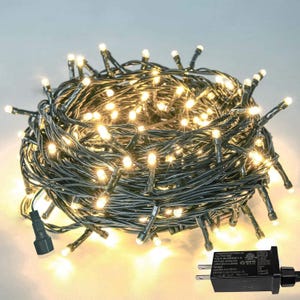 Peut inclure: Un ensemble de guirlandes lumineuses à LED blanc chaud avec un fil vert. Les lumières sont regroupées, avec un adaptateur secteur et une prise noirs. Convient pour une utilisation intérieure ou extérieure.