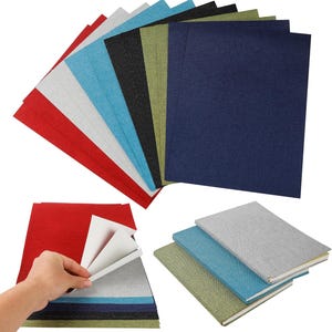 May include: A selection of textured notebooks in a range of colours, including red, grey, blue, and green. Some notebooks are fanned out, while others are stacked. A hand is shown lifting the pages of a red notebook.