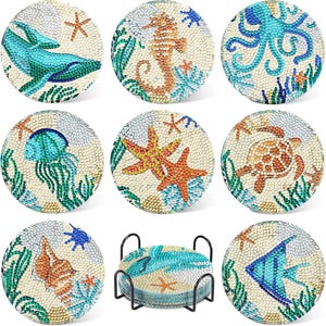 May include: A set of nine round coasters with a marine theme. Each coaster features a different sea creature, such as a whale, seahorse, octopus, jellyfish, starfish, turtle, seashell, and fish, all decorated with sparkling embellishments.