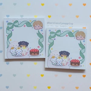 May include: Two square sticky note pads featuring a light green ribbon border, a cartoon character head, small stars, and a group of illustrated animals including a black puppy and a chocolate cake with strawberries. Text reads @harmlesslynapping.