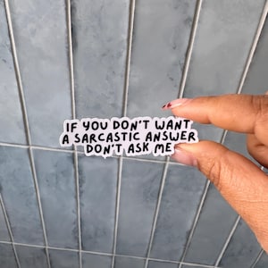 May include: A white die-cut sticker with a black border and black text that reads, IF YOU DON'T WANT A SARCASTIC ANSWER DON'T ASK ME. The sticker features a bold, sans-serif font and has a clean, matte appearance with a simple, readable design.