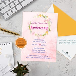 May include: A retirement card with a floral wreath design and German text. The card is on a marble surface with a keyboard, pens, and an envelope. The card includes the text "Alles Gute zum Ruhestand."