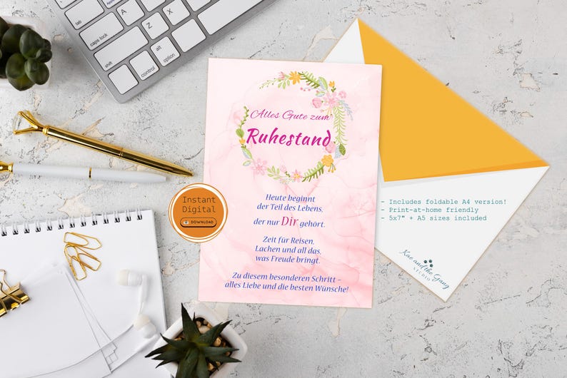 May include: A retirement card with a floral wreath design and German text. The card is on a marble surface with a keyboard, pens, and an envelope. The card includes the text "Alles Gute zum Ruhestand."