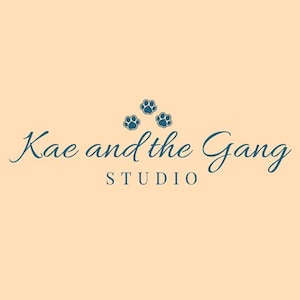 May include: A logo with the text "Kae and the Gang STUDIO" in a teal script font, with three teal paw prints above the word "Gang". The background is a light peach color.
