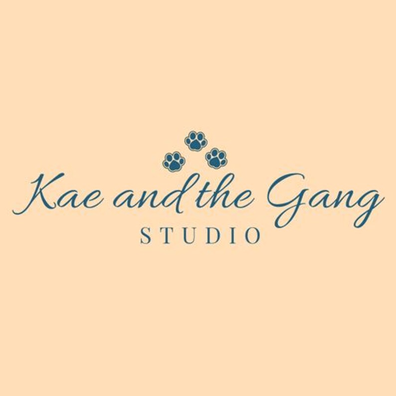 May include: A logo with the text "Kae and the Gang STUDIO" in a teal script font, with three teal paw prints above the word "Gang". The background is a light peach color.