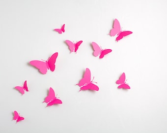 May include: A white background with pink paper butterflies of various sizes and shapes.