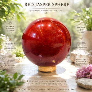 Könnte beinhalten: Eine polierte rote Jaspiskugel mit natürlichen Mustern und tiefroter Farbe, die auf einem kleinen Holzständer ruht. Die Kugel hat einen Durchmesser von 270 mm. Der Text auf dem Bild enthält Red Jasper Sphere, Strength, Stability, Vitality.