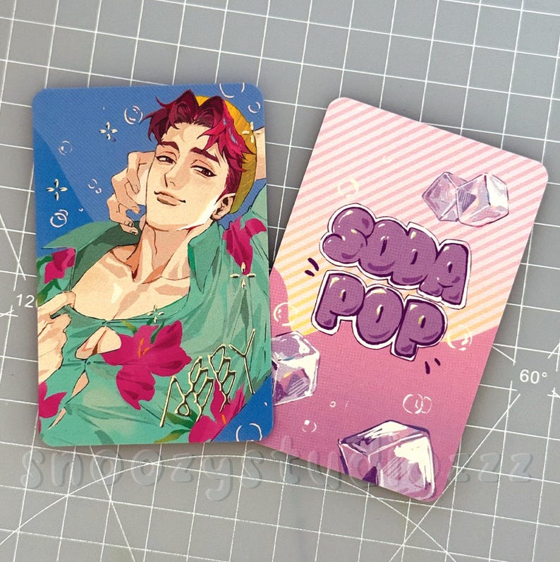 K&ouml;nnte beinhalten: Zwei rechteckige Karten mit abgerundeten Ecken. Eine Karte zeigt die Illustration einer Person mit magentafarbenem Haar in einem gr&uuml;nen Blumenhemd. Die andere hat einen rosa gestreiften Hintergrund mit dem violetten Text SODA POP und Eisw&uuml;rfeln.