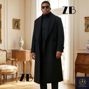May include: A long, black overcoat with a wide lapel and large pockets. The coat is worn over a black turtleneck. The letters "ZB" are visible in the upper right and lower left corners of the image.