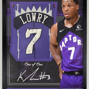 May include: Framed artwork featuring Kyle Lowry of the Toronto Raptors. The image includes a jersey with the number 7 and the name "LOWRY". The artwork is labeled "National Treasures" and includes Lowry's signature. The jersey is purple and black.