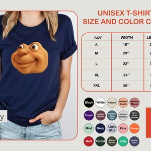 May include: Navy blue unisex t-shirt featuring a cartoon character's face. The size and color chart shows measurements in inches. Available colors include black, white, and navy.