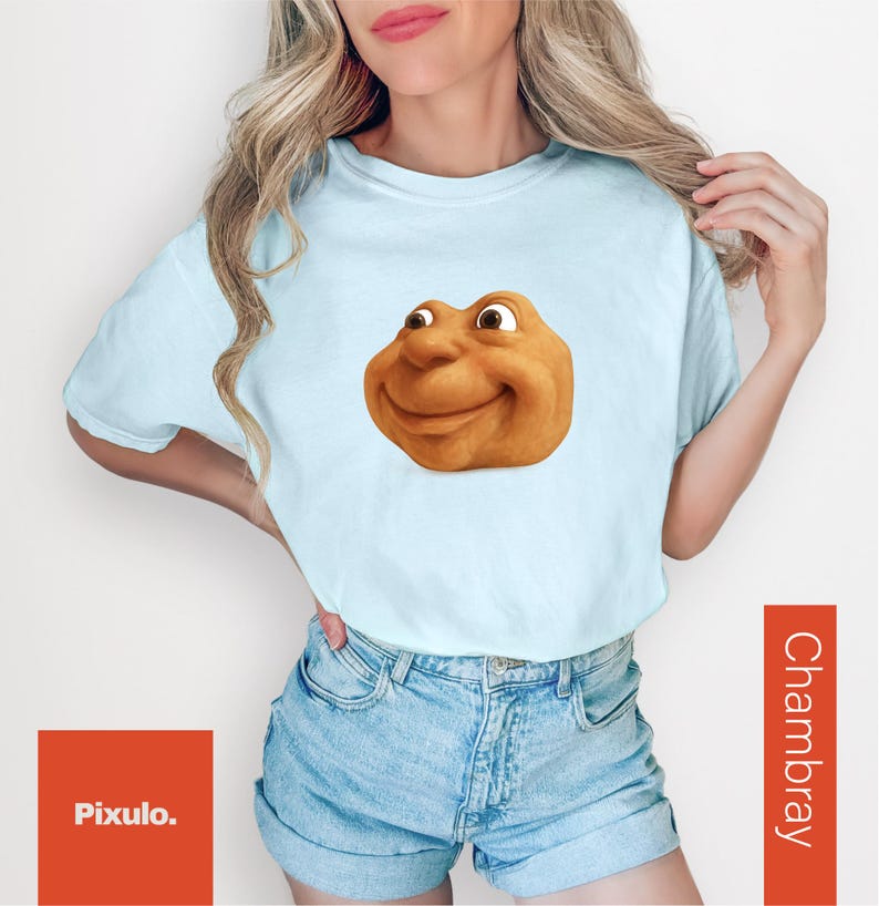 May include: Light blue t-shirt featuring a cartoon character with a smiling face. The shirt is paired with denim shorts. The word "Chambray" is printed vertically on the right side of the image. The Pixulo logo is in the bottom left corner.