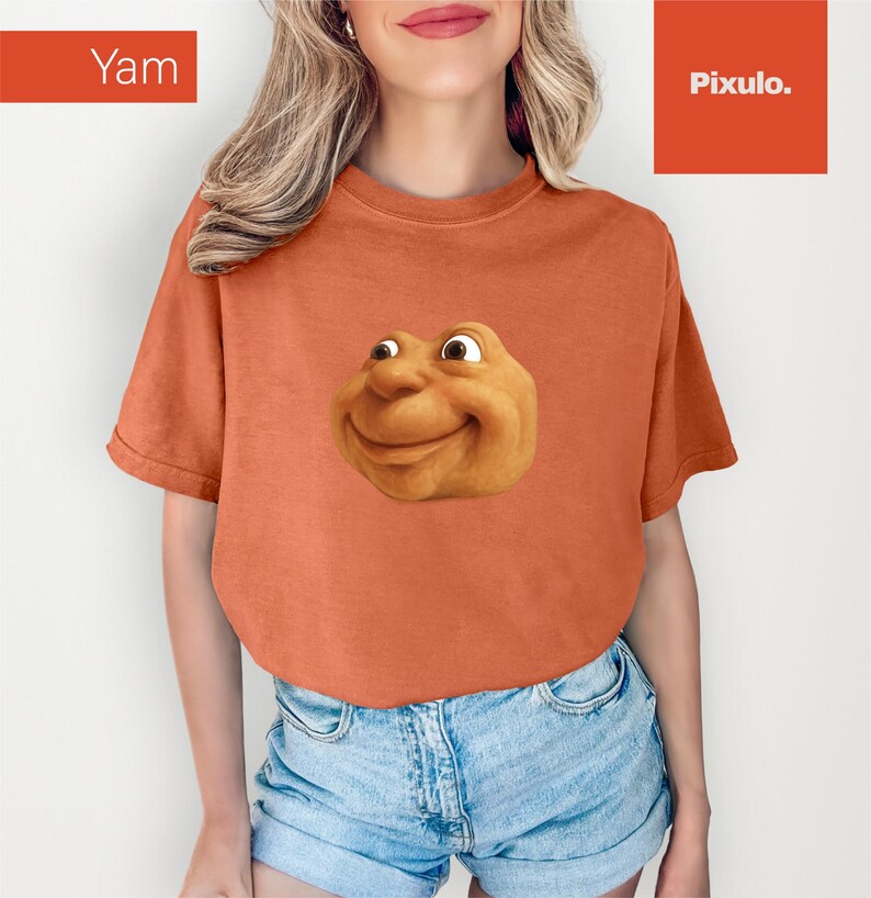 May include: Orange t-shirt with a smiling, cartoonish face graphic. The word "Yam" is in a box in the upper left corner. The shirt is paired with denim shorts.