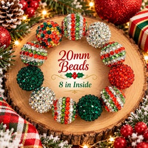 May include: A circular arrangement of 20mm beads featuring red, green, and silver rhinestone finishes. The center text reads 20mm Beads and 8 in Inside. The beads are spherical and covered in small, reflective crystals in festive holiday colors.