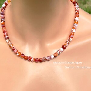 May include: A necklace of Mexican Orange Agate beads, in shades of orange, red, and white. The beads are 6mm in size. The necklace is displayed on a person. The text on the image says "6mm or 1/4 inch beads".