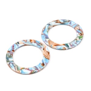 May include: Two round, blue, brown, and white marbled plastic rings.