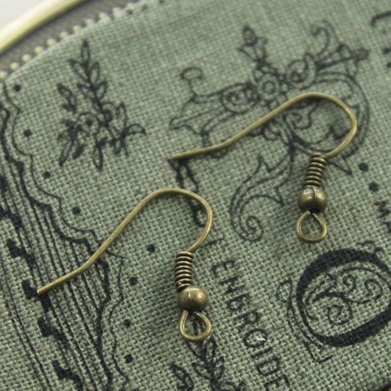 May include: Two gold-toned earring hooks with a spring and a small ball at the end.