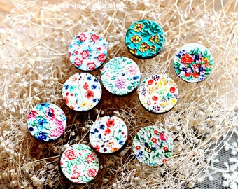 May include: Ten round wooden buttons with colorful floral patterns. The buttons are painted with a variety of flowers, including roses, daisies, and wildflowers. The buttons are perfect for adding a touch of whimsy to any project.