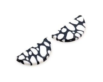 May include: Two black and white patterned half-circle ceramic tiles.