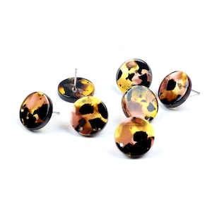May include: Six round, brown, yellow, and black patterned earrings with silver posts.