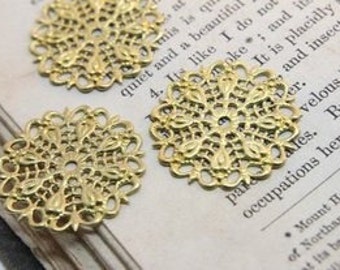 May include: Three gold metal filigree embellishments with a circular shape and intricate designs. The embellishments are approximately 1 inch in diameter.