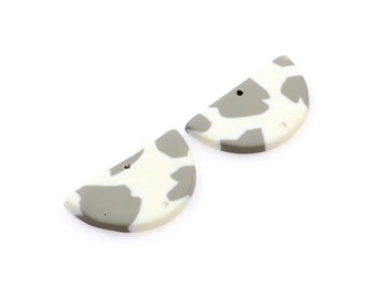 May include: Two half-circle shaped polymer clay earrings with a white and gray cow print pattern. The earrings have a hole for a hook.