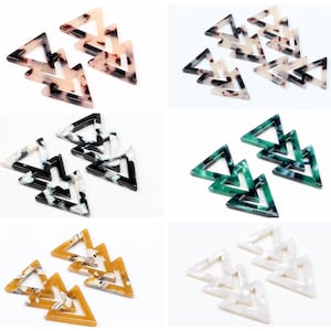 May include: Set of six triangle-shaped acrylic charms with a marbled pattern in various colors, including brown, black, white, green, and yellow.