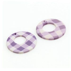 May include: Two purple and white gingham patterned round wooden earrings with a hole at the top for hanging.