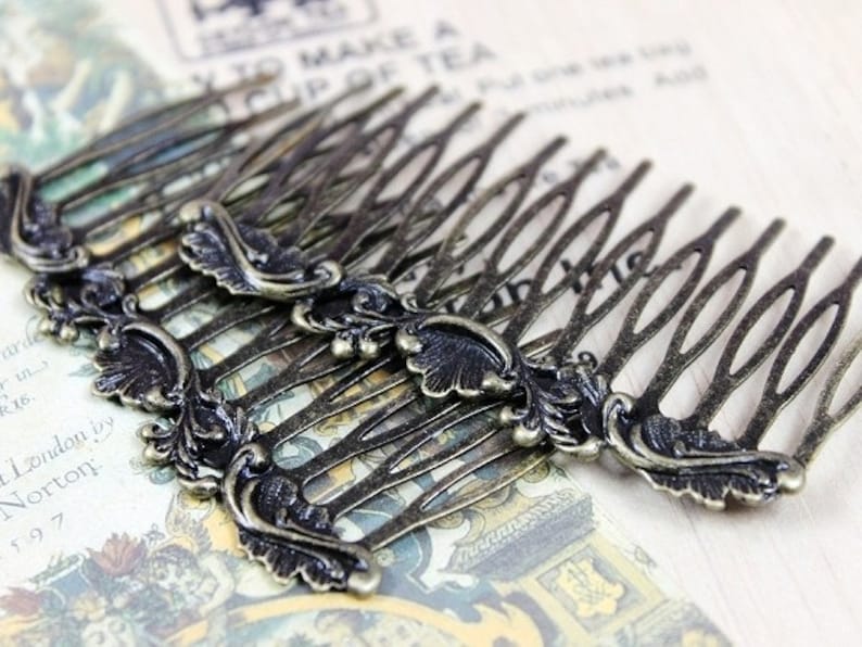 May include: A set of six antique gold hair combs with ornate floral designs. Each comb has a decorative flourish at the end.