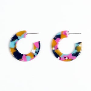 May include: A pair of colorful hoop earrings with a marbled pattern in shades of pink, blue, yellow, and black.