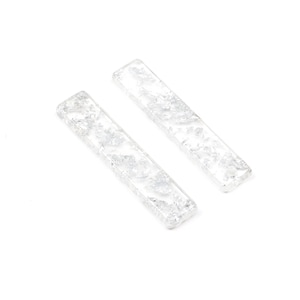 Könnte beinhalten: Zwei transparente Haarklammern aus Glas mit einem silbernen Glitzermuster.