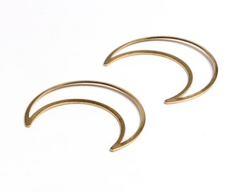 May include: A pair of gold crescent moon earrings. The earrings are made of thin metal and have a simple, minimalist design.
