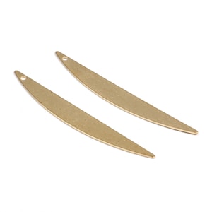 Puede incluir: Dos formas de media luna de metal dorado con un pequeño agujero en la parte superior para colgar.