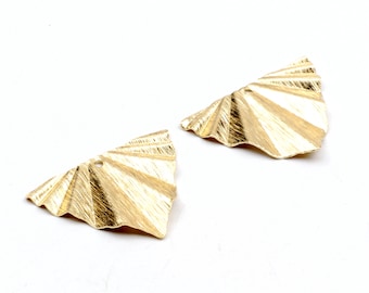 May include: Two gold-colored metal earring charms in the shape of a fan. The charms have a textured surface and a hole at the top for attaching to earrings.