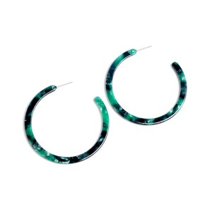 May include: A pair of green and black hoop earrings. The earrings are made of a marbled plastic material.