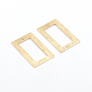 May include: Two gold-toned metal rectangular frame charms with a brushed finish. Each charm has a small hole at the top for attaching to jewelry.