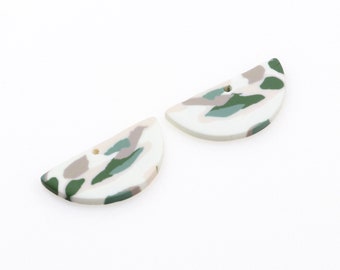 May include: Two half-circle shaped ceramic earrings with a white base and a green, pink, and white abstract pattern.