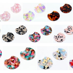 Peut inclure: Assortiment de 20 cabochons en résine semi-circulaires et colorés avec un motif marbré. Les cabochons mesurent environ 2,5 cm de diamètre.