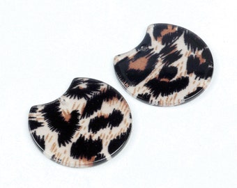 May include: Two half-circle shaped earrings with a leopard print design. The earrings are made of a clear plastic material and have a brown, black, and white pattern.