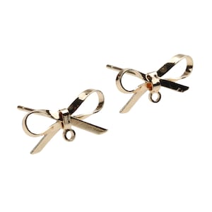 May include: A pair of gold bow-shaped earrings. The earrings are made of thin metal and have a simple design.