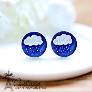 May include: A pair of blue and white wooden earrings with a cloud and raindrops design.