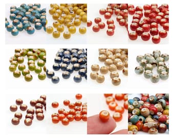 May include: A collection of ceramic beads in various colors, including blue, yellow, red, green, and brown. Each bead has a speckled or glazed finish and a hole for stringing. Ideal for jewelry making and crafts.